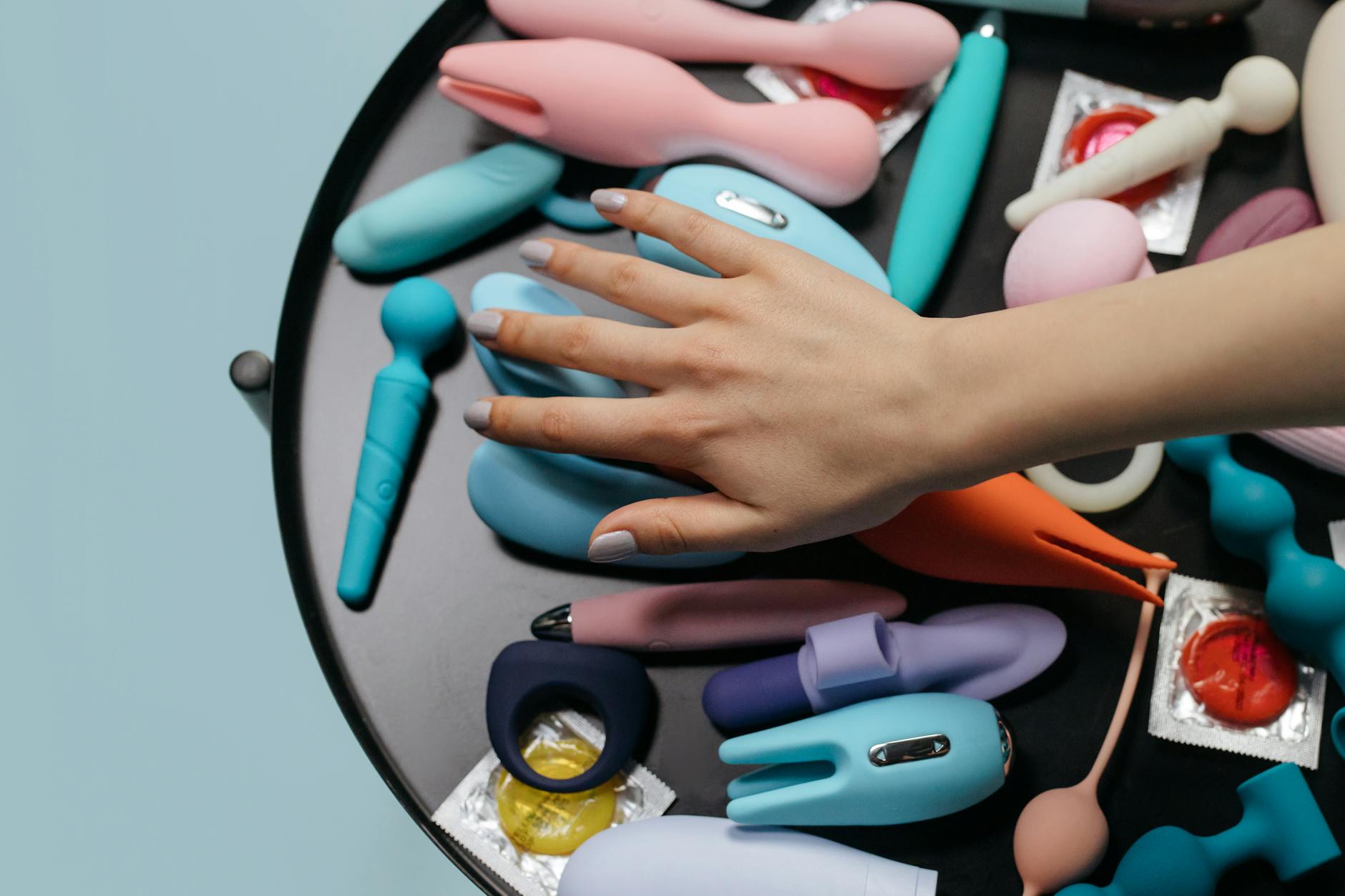 A young couple standing together indoors, holding a blue vibrator, symbolizing modern intimacy and shared exploration
