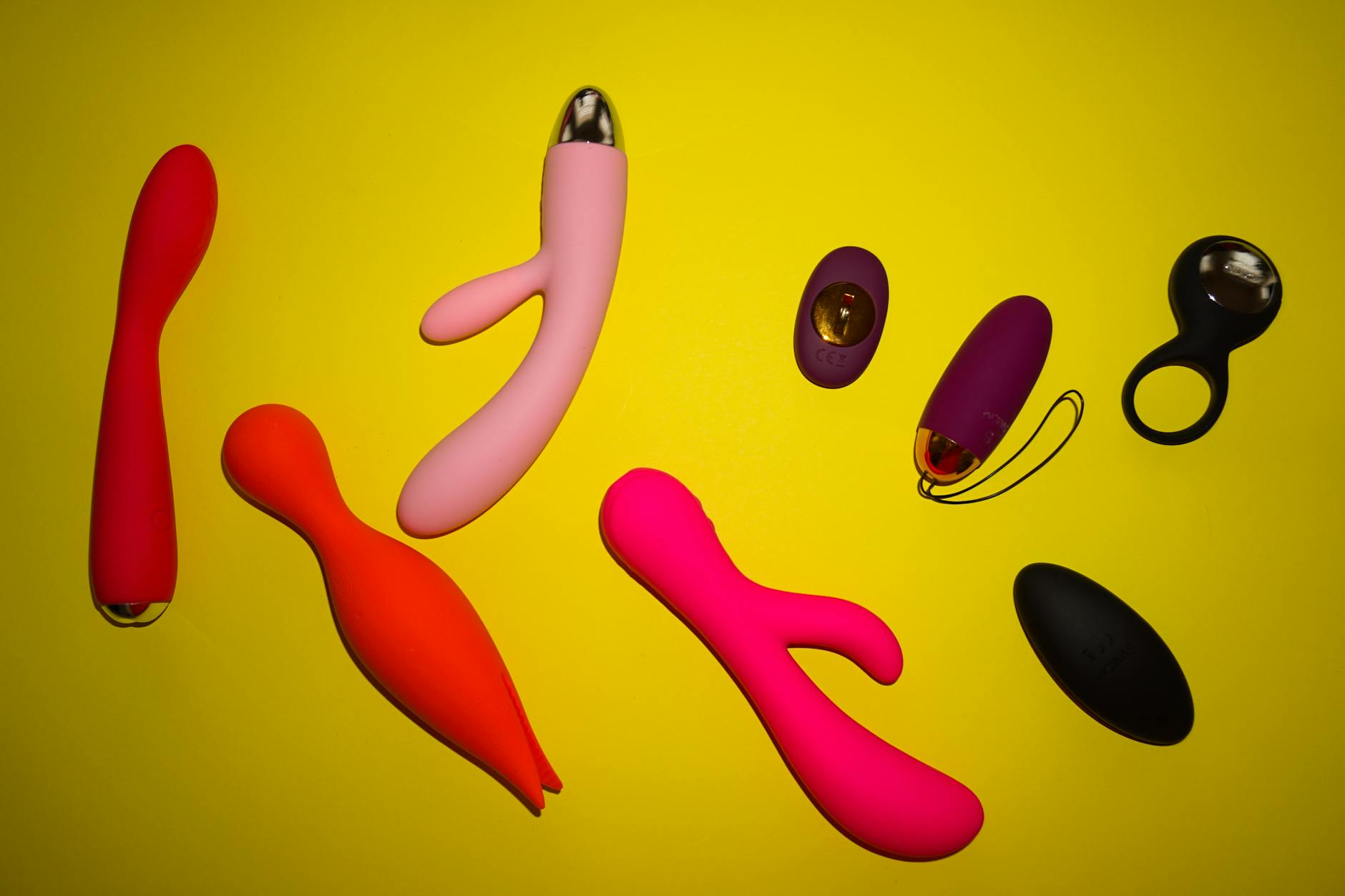Hand holding a colorful vibrator against a purple background, representing renewal and pleasure recovery