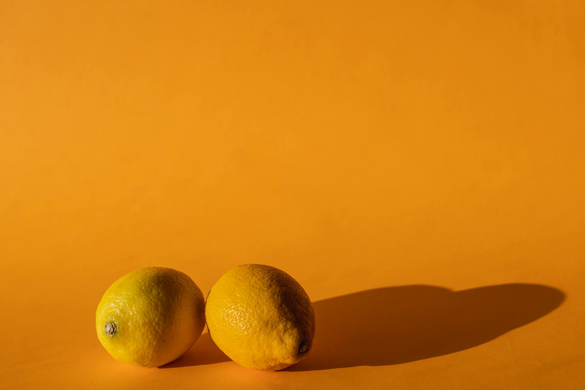 Ripe lemons arranged on a yellow background, symbolizing cycle phases and seasonal shifts in sensation