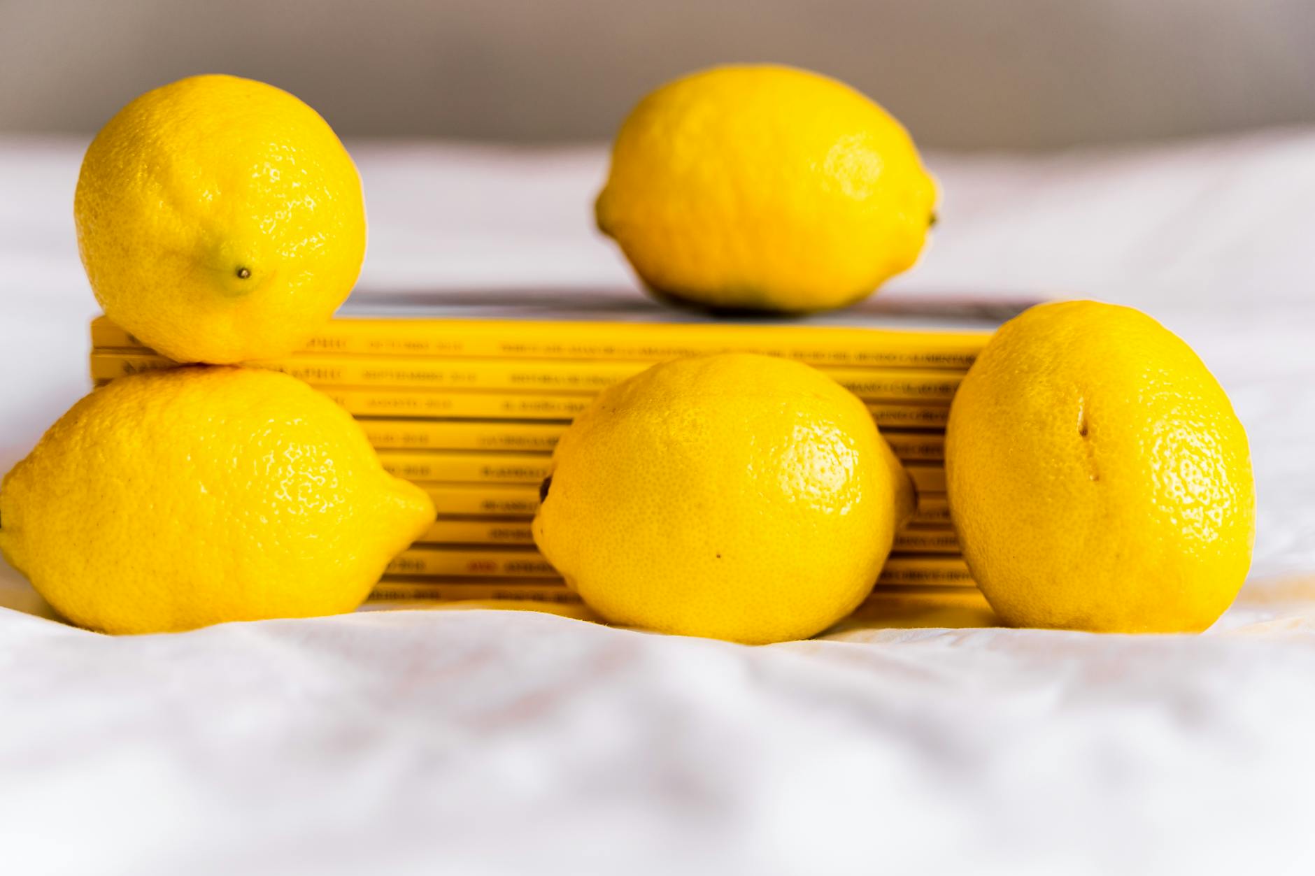 Fresh lemons arranged with stacked books on a white tablecloth, symbolizing natural solutions and relationship renewal